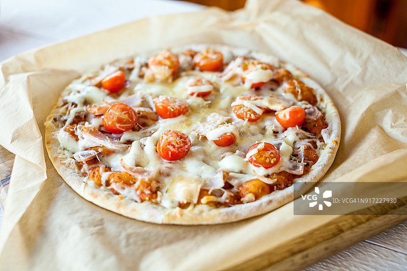 热新鲜的自制传统意大利披萨放在木桌上。披萨墙纸和烹饪食品的概念。软焦点图片素材