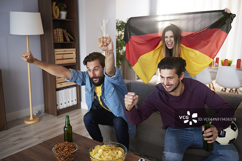 激动的德国足球迷一边看电视一边欢呼图片素材
