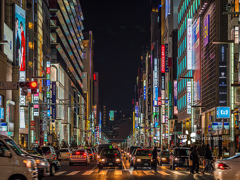 在日本东京市中心，霓虹招牌下的奢侈品购物街，银座大街上排列着昂贵品牌的商店图片素材
