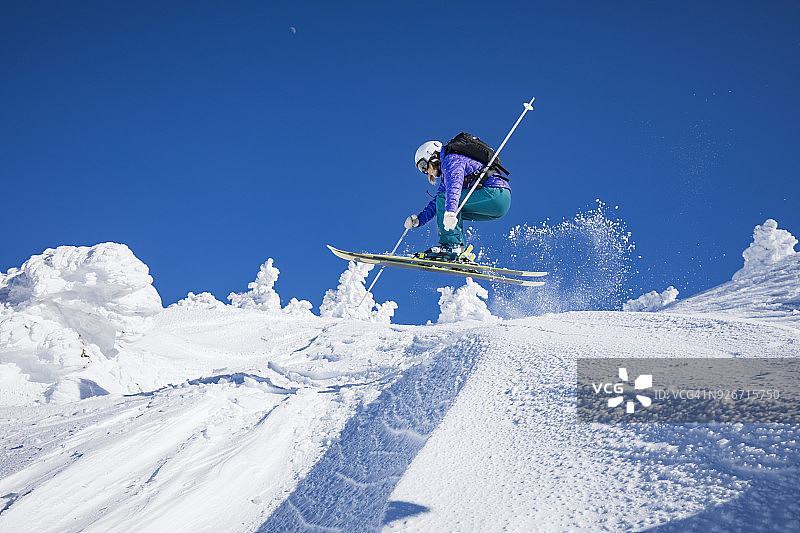 女子在滑雪日的跳跃图片素材