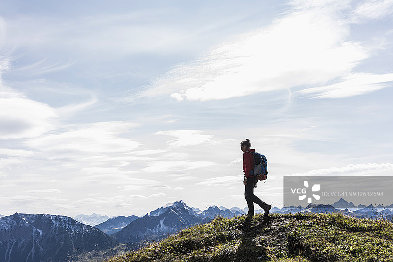 奥地利，蒂罗尔，一个在山里徒步旅行的年轻女子图片素材