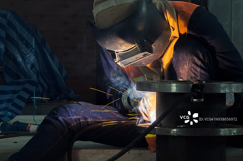 工业焊工在工厂中焊接装配式建筑。焊接过程中采用金属电弧焊(SMAW)或焊条焊接。图片素材
