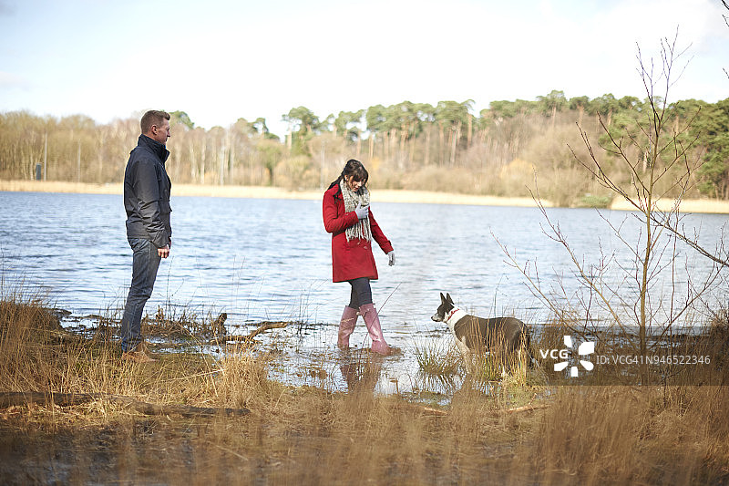 一对年轻夫妇在湖边的树林里散步图片素材