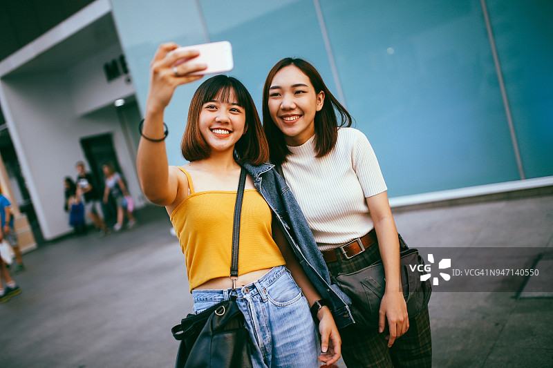 年轻的亚洲女性一起在曼谷购物，用手机自拍图片素材
