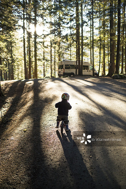 加拿大不列颠哥伦比亚省哈里森温泉森林里骑着儿童自行车的小男孩图片素材