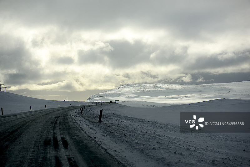 冰岛西部Baularvallavatn附近蜿蜒的道路和壮观的天空图片素材