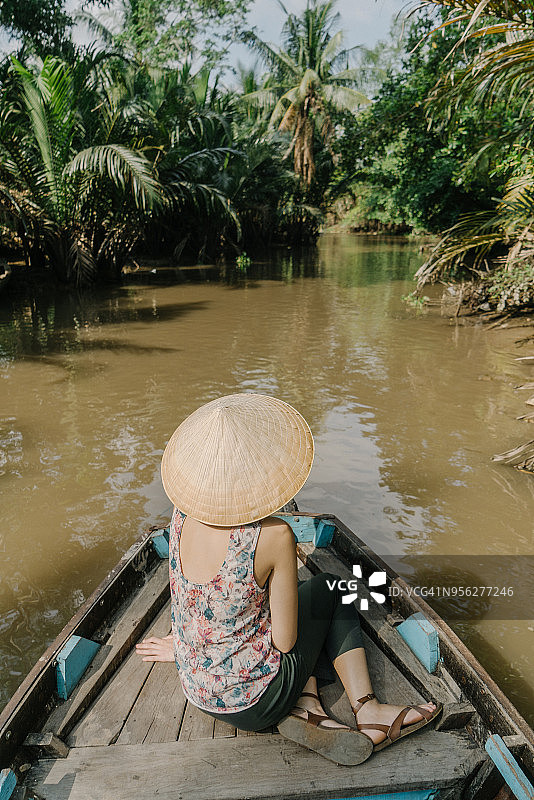 一名妇女乘船穿过湄公河三角洲图片素材