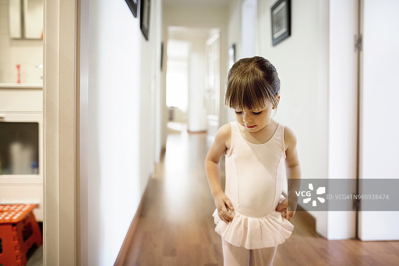 可爱的女孩穿着芭蕾舞服站在家里图片素材