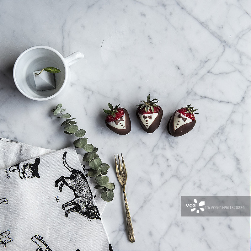 俯视图巧克力覆盖草莓与叉子在桌子上图片素材