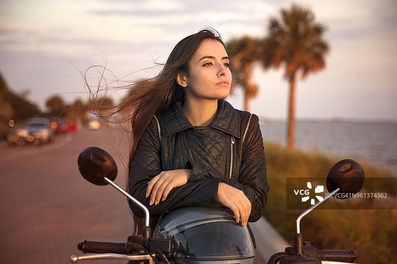年轻女子在街上骑摩托车的特写图片素材