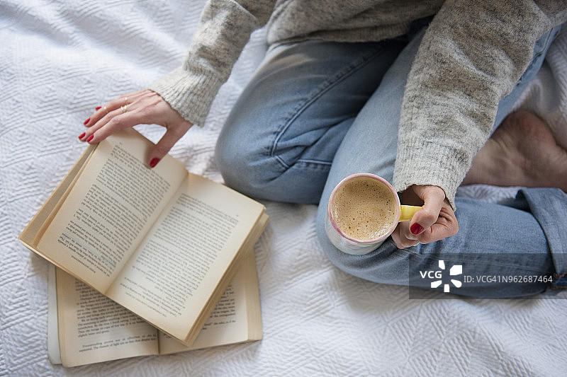 在床上喝咖啡看书的女人图片素材