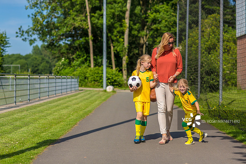 足球妈妈陪她的两个女儿参加足球训练图片素材