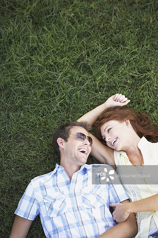 幸福的夫妇躺在草地上图片素材