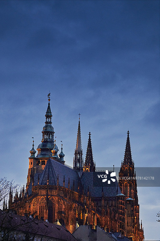 布拉格城堡的圣维塔斯大教堂，在夜晚，橙色的泛光灯照亮了深蓝色的天空图片素材