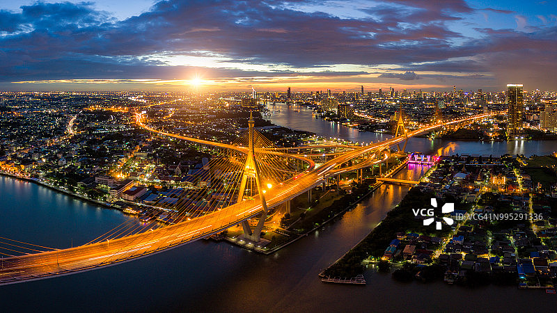 鸟瞰图普密蓬悬索桥横跨湄南河在曼谷市与汽车在桥上在日落的天空和云在曼谷泰国。图片素材