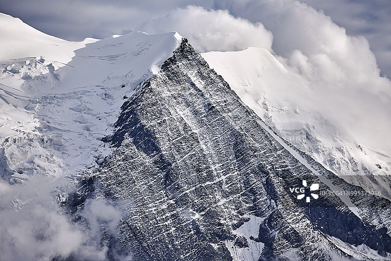 白雪覆盖的特写，三角形的法国阿尔卑斯山脉与大气云图片素材