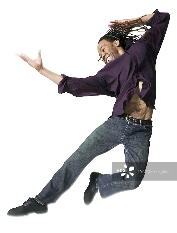 一个穿着紫色衬衫的年轻成年男子的全身照片，他在空中横向跳跃图片素材