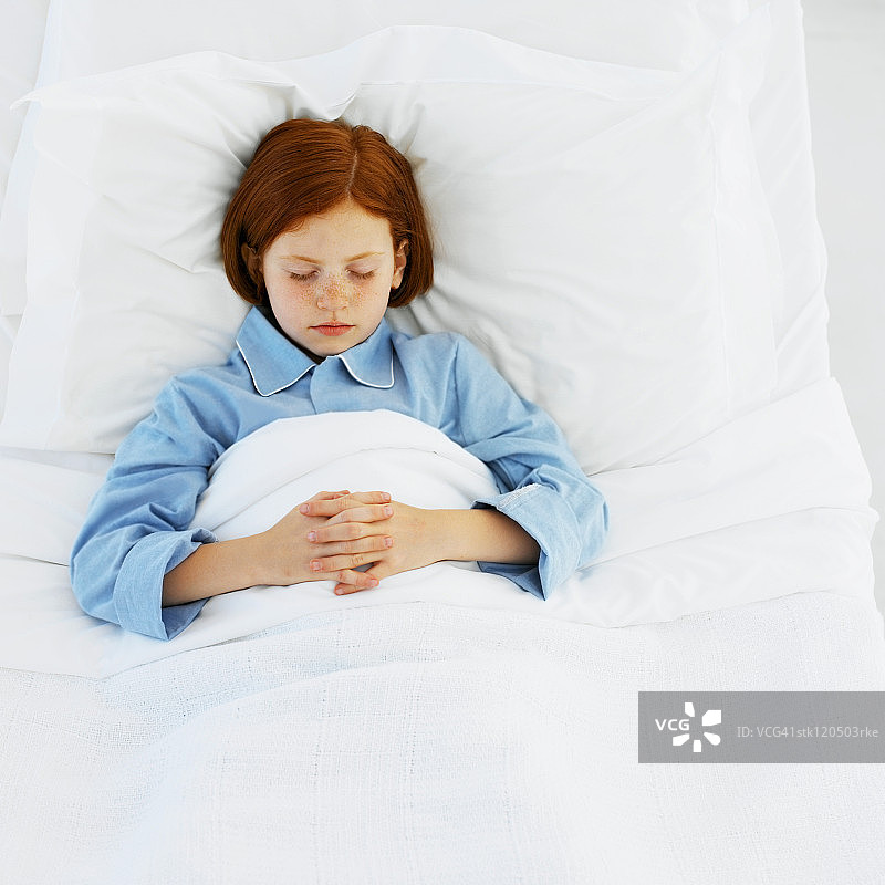 一个年轻的女孩(8-10)在医院的床上睡觉图片素材