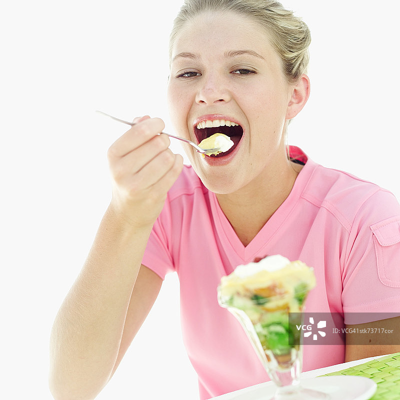 一个女人用勺子吃冰淇淋的肖像图片素材