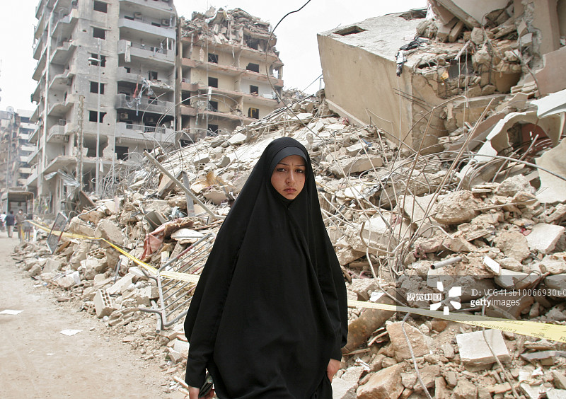黎巴嫩，贝鲁特，一名年轻女子走过被战争摧毁的城市废墟图片素材
