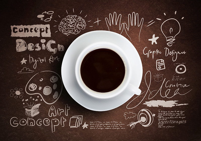 咖啡休息。近距离的一杯咖啡在桌子上与草图的背景图片素材