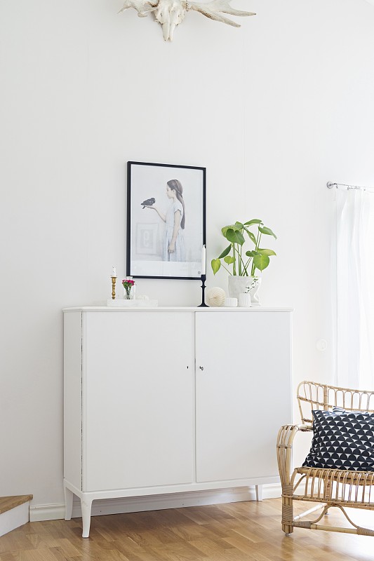 白色半高柜，黑框画和柳条扶手椅，黑白散垫图片下载
