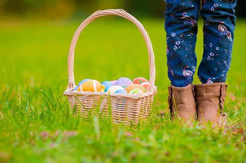 近距离观察草地上篮子里五颜六色的复活节彩蛋图片素材