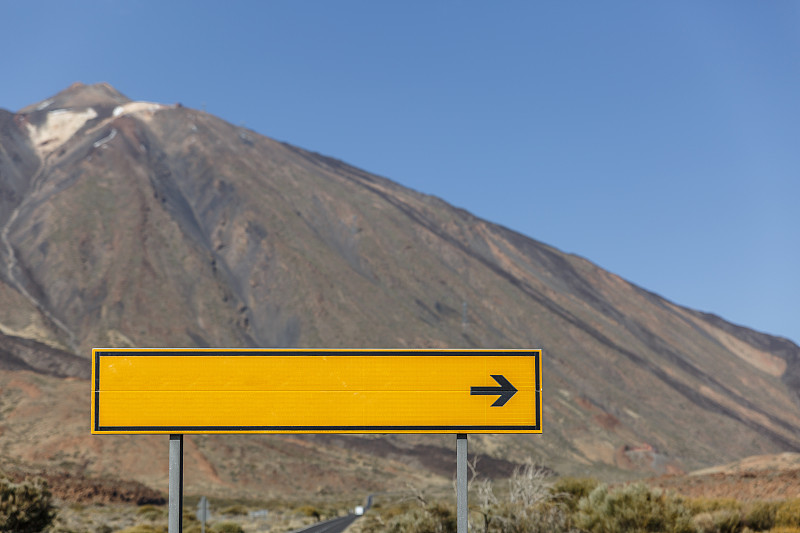 一个黄色的标志显示一个地址在一个大火山的中间图片下载