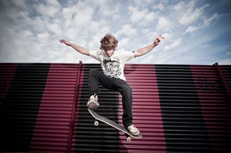 年轻滑板运动员跳图片下载