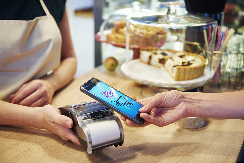 顾客在咖啡馆用智能手机支付无现金图片下载