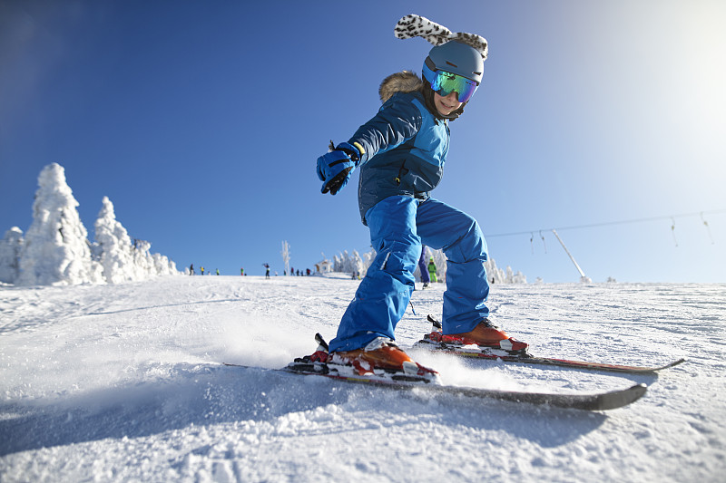 一个小男孩在一个美丽的冬日滑雪图片下载