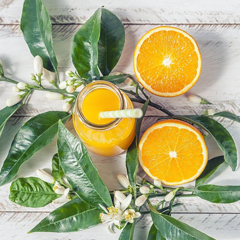 新鲜的橘子和果汁瓶在乡村白色木材背景图片素材