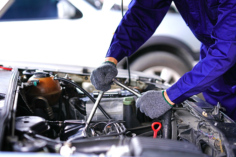 汽车修理工使用修理工具在车库检查汽车图片下载