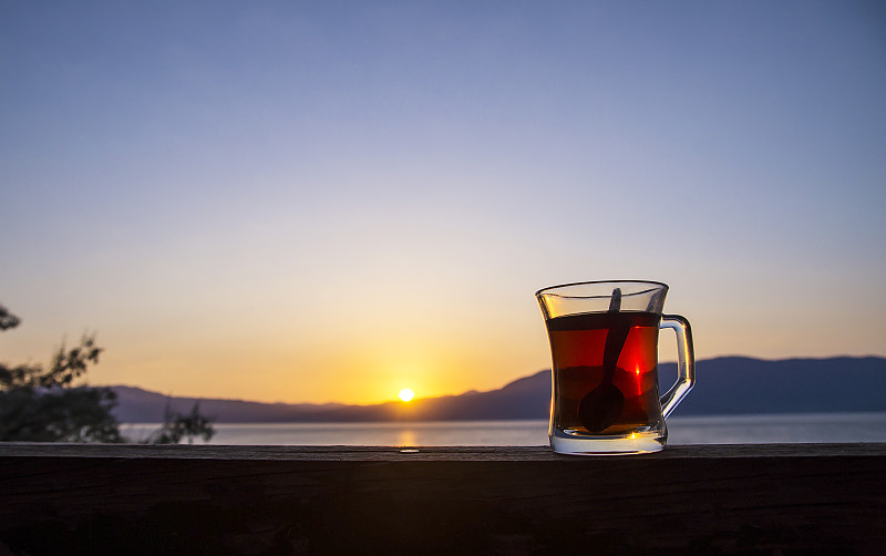 在土耳其Burdur湖日落时一杯土耳其茶图片下载