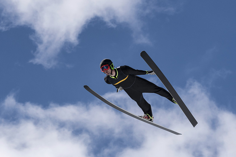 前视图的男子跳台滑雪在半空中对多云的天空图片下载
