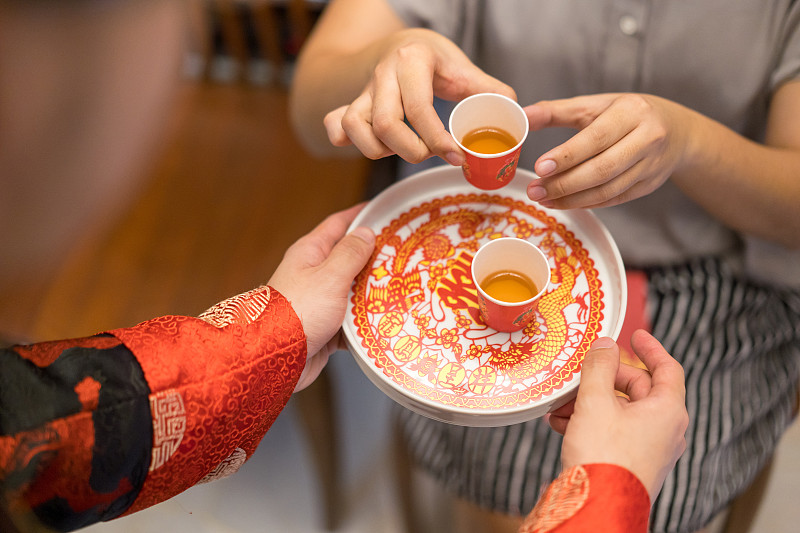 新婚夫妇在中国传统茶道上给老人斟茶图片下载