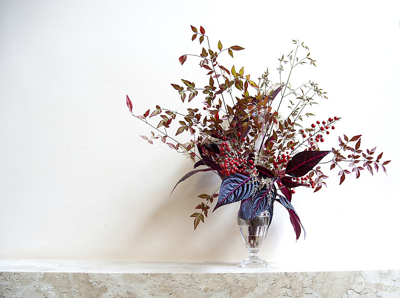 一个单独的花瓶，上面有秋季植物和插花。图片下载
