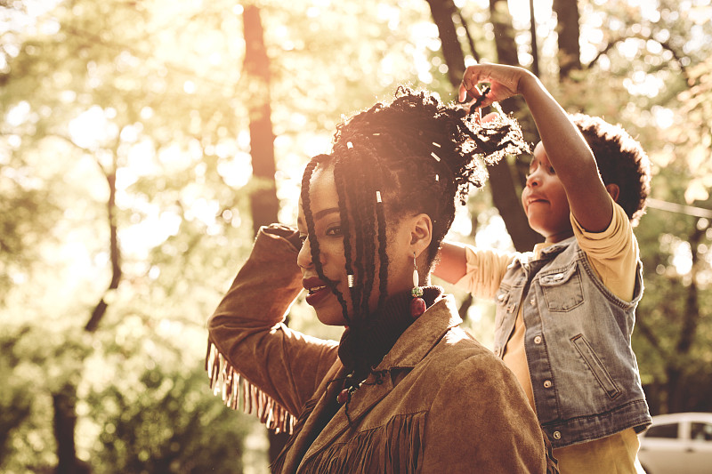 非裔美国小女孩在公园里给妈妈做发型。图片下载