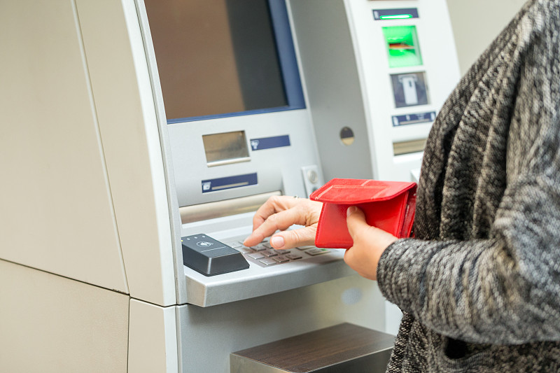 在ATM机输入密码的资深女性图片素材
