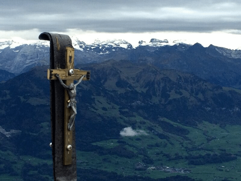 在瑞士阿尔卑斯山的十字架与缓慢移动的云图片下载