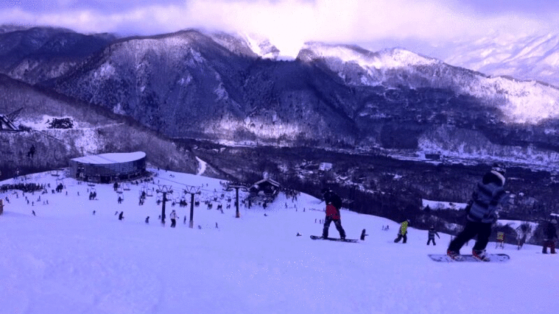 滑雪者和滑雪板在滑雪斜坡与山的背景图片下载