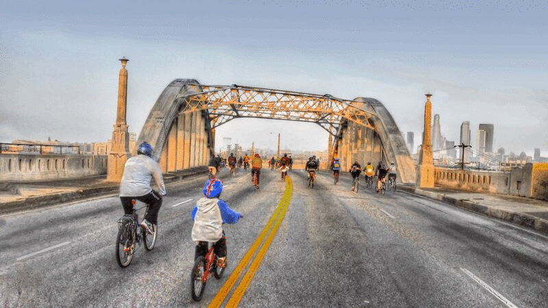 日出时骑自行车的人过桥的后视图图片下载