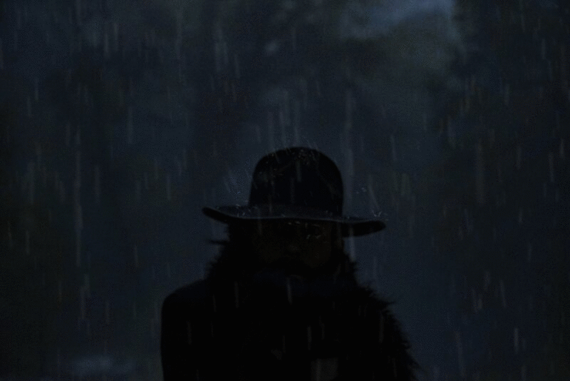 戴着帽子的神秘男子站在暴风雨中，脸部分被闪电暴露图片下载