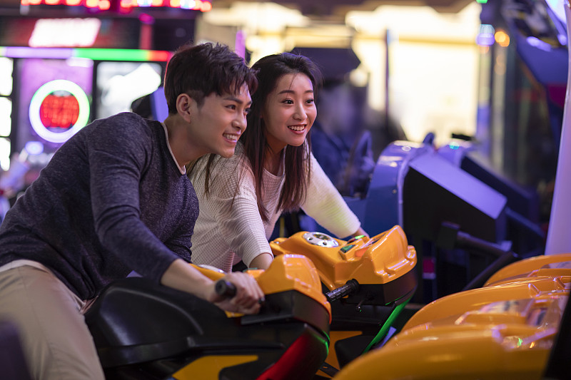 快乐的年轻情侣玩街机游戏图片下载