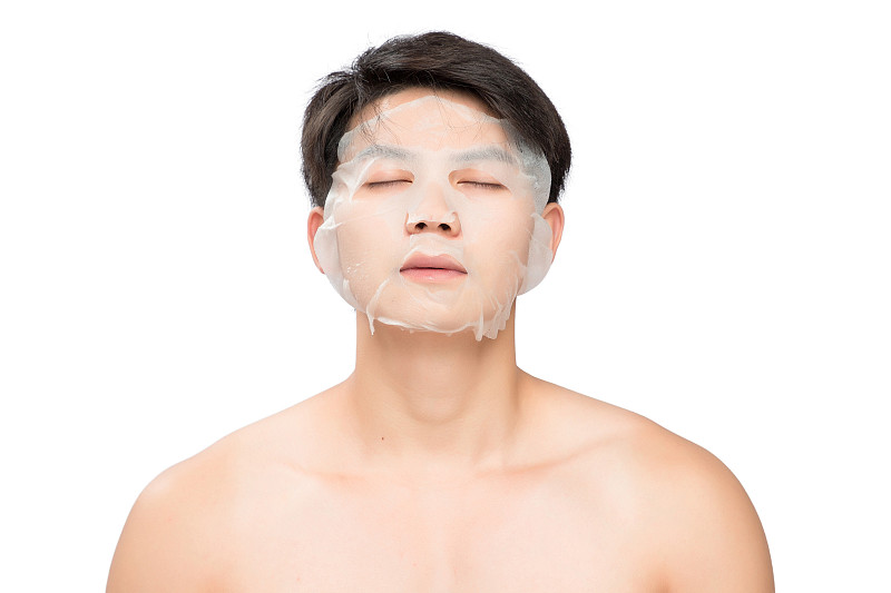 白色背景里的敷着面膜的亚洲男士面部特写，化妆护肤整容图片素材