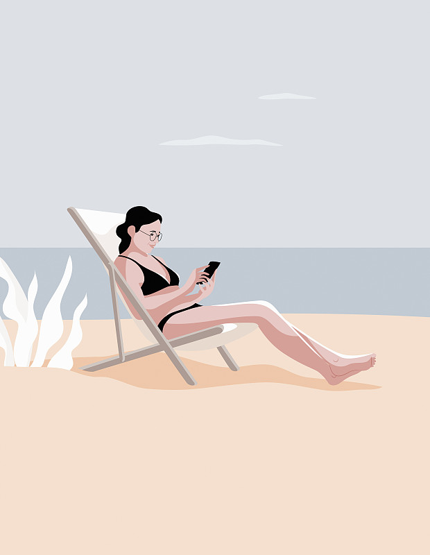 在海滩上玩智能手机的女人图片素材