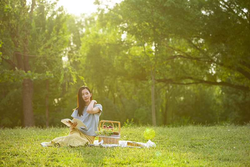 年轻女子户外郊游野餐看书图片素材