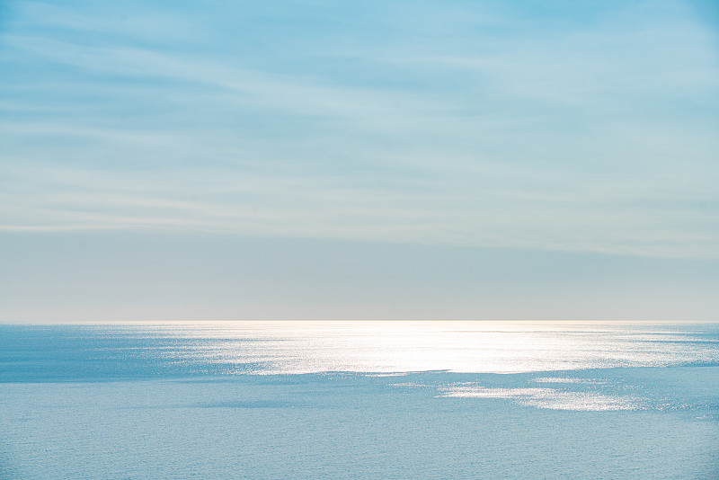 阳光下平静的海平面图片素材