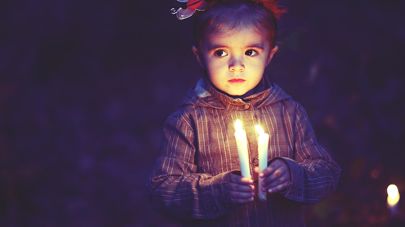 被烛光照亮的小女孩图片素材