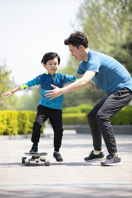 快乐的父子俩玩滑板图片素材